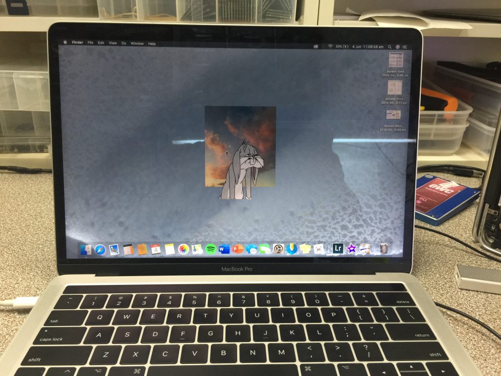 MacBook screen with visible water marks in the backlight background.